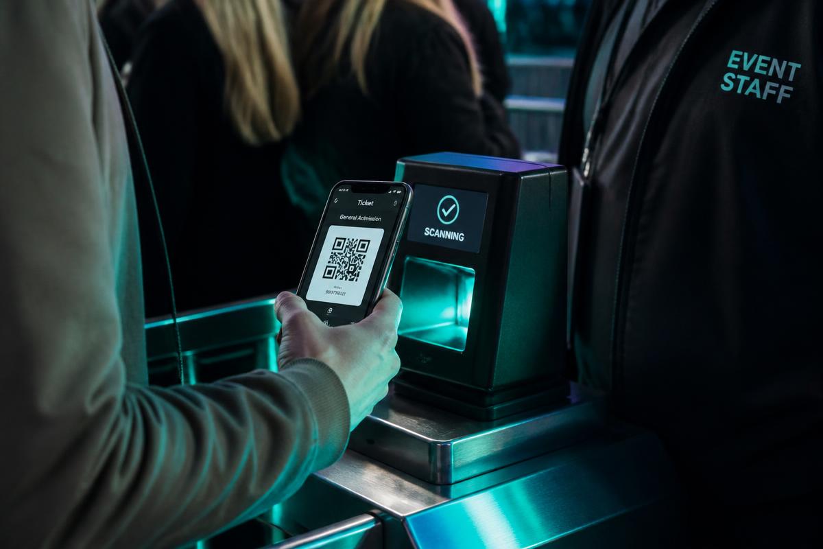 Guest scanning a QR ticket at a venue turnstile